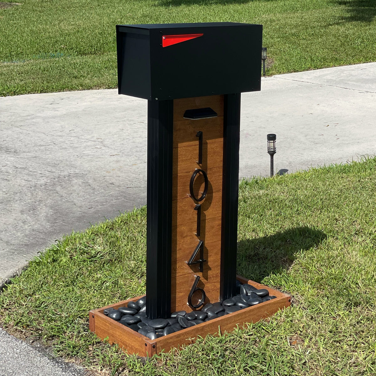 A smooth modern aluminum mailbox installed at a residential curb