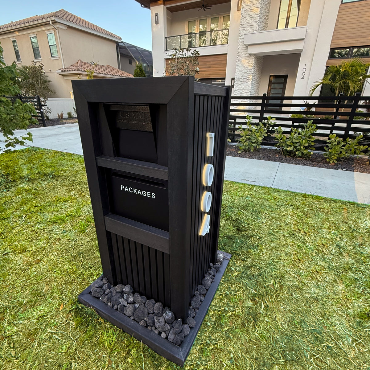 A faux marble package vault mailbox with a locking parcel drop in front of a home