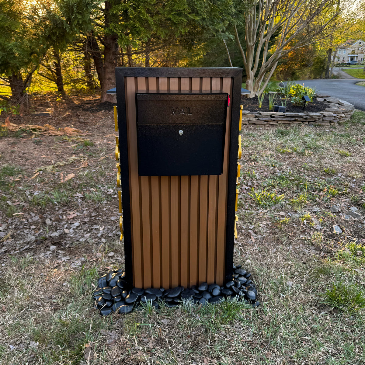 A composite mailbox mounted in front of a modern home