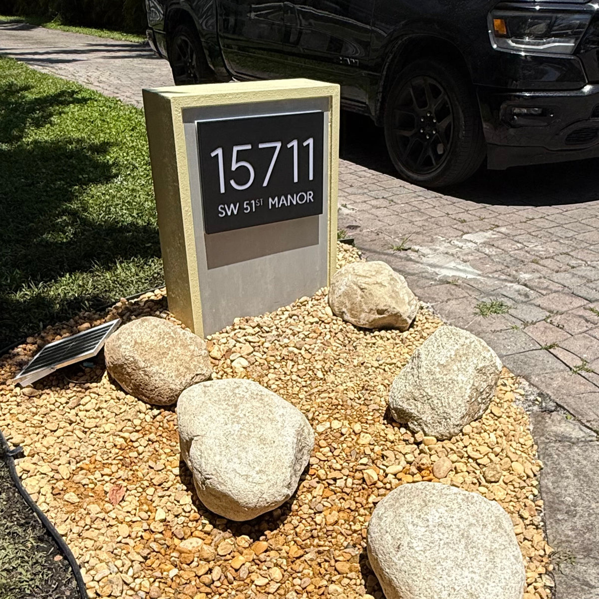 A backlit LED address plaque glowing at dusk on a residential mailbox