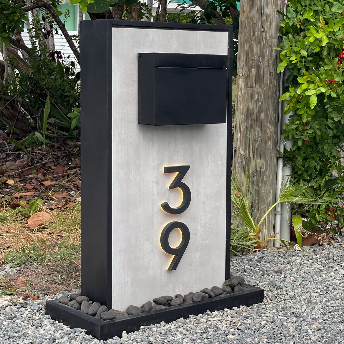 A modern mailbox with a clean, legible house number at the end of a driveway