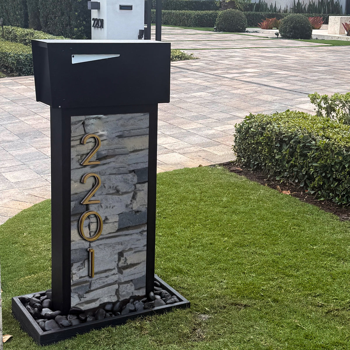 A slate-toned stone-finish mailbox that echoes a neighborhood's material palette