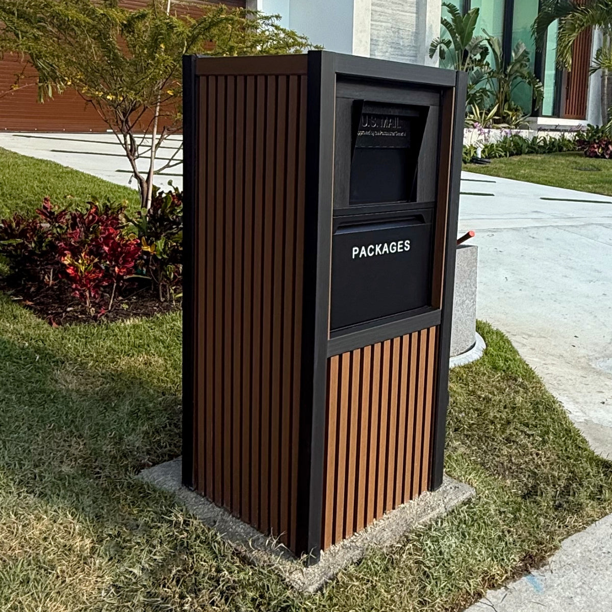 A sleek black VaultBox package vault beside a modern entryway