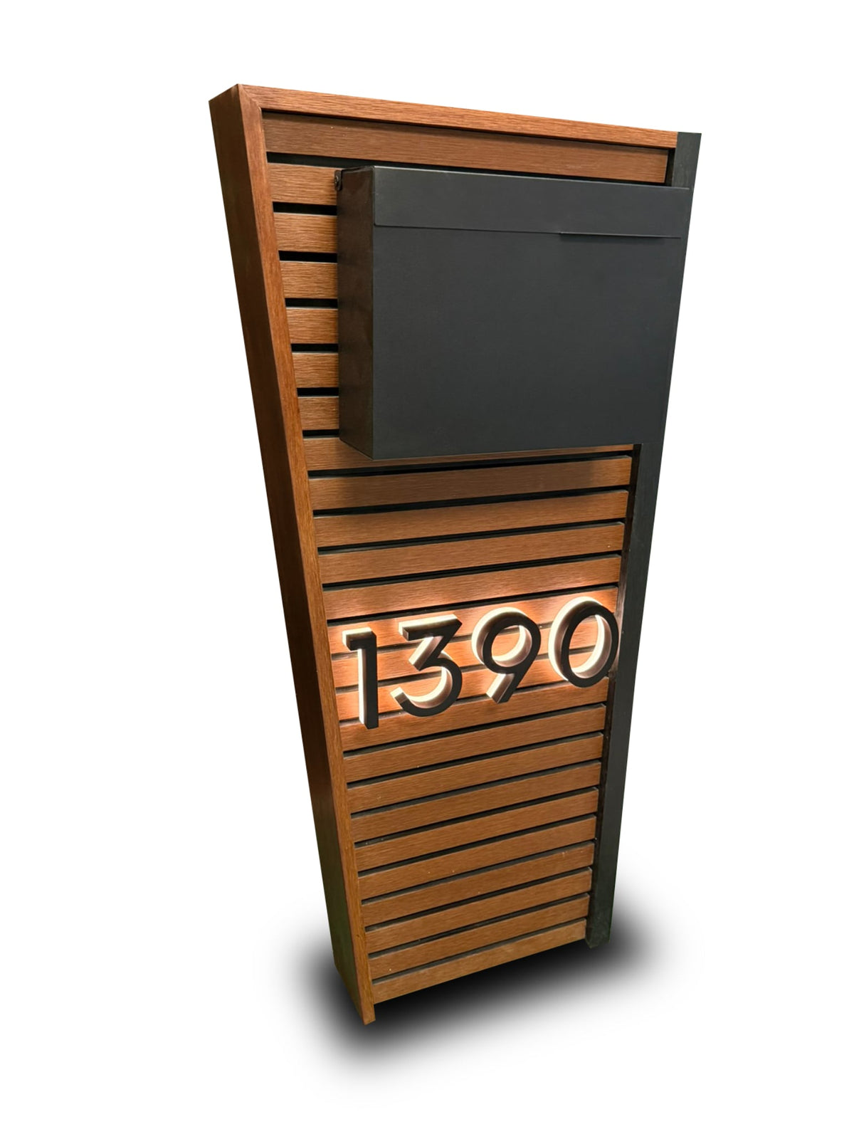 Close view of a composite mailbox with backlit house numbers glowing against a modern facade